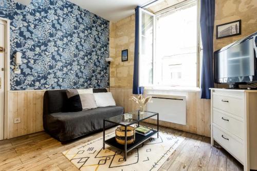 een woonkamer met een bank en een tv bij Lurbe Bleue - Bordeaux central et calme in Bordeaux