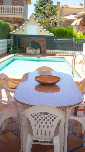a table and chairs next to a swimming pool at Villa Luis R in Cájar