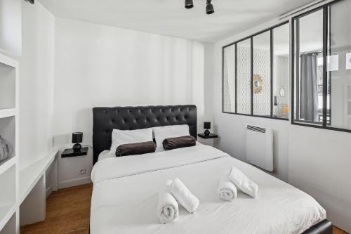 - une chambre blanche avec un grand lit et trois oreillers dans l'établissement Studio au Cœur du Marais, Rue des Rosiers!, à Paris