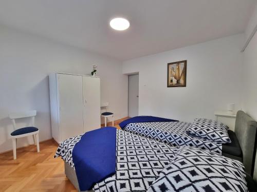 a bedroom with a bed with blue and white sheets at Apartment Anka in Omiš