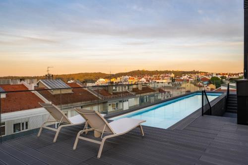 a balcony with two chairs and a swimming pool at Mirabilis Apartments - LX Living in Lisbon