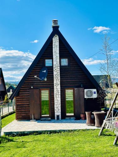 a house with a gambrel roof with two doors at Guest House LENA in Žabljak
