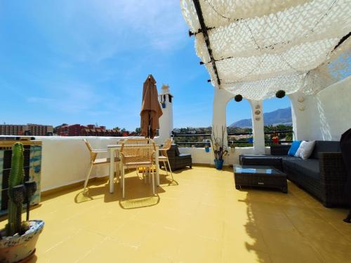 a balcony with a couch and a table and chairs at Happy Holiday Home! Pueblo Evita Charming Condo in Benalmádena