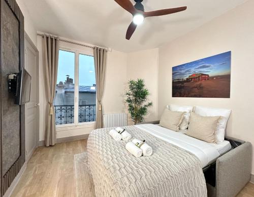 a bedroom with a large bed with a ceiling fan at 1562 - Cosy Montmartre in Paris Olympic Games 2024 in Paris