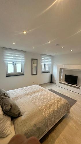 a bedroom with a large bed and a flat screen tv at Ferienwohnung Mentes in Füssen
