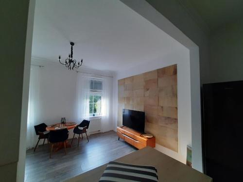 a living room with a television and a table and chairs at Apartament GALERIA in Nysa