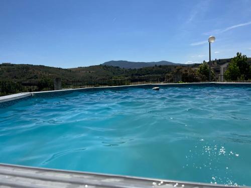 una piscina blu con montagne sullo sfondo di Chelas Rural AL a Mirandela