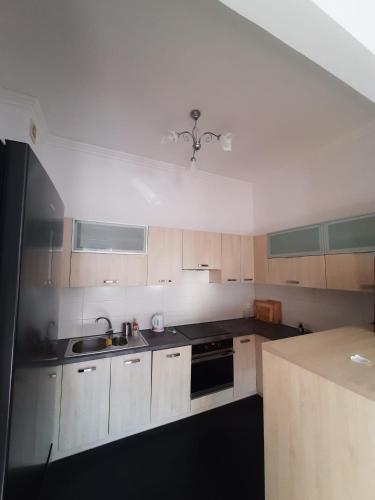 a small kitchen with white cabinets and a sink at Apartament GALERIA in Nysa