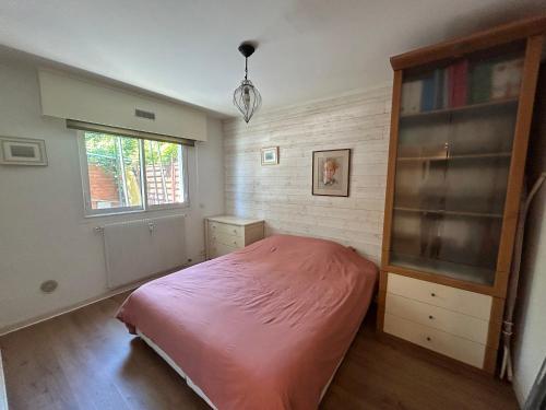 - une chambre avec un lit rose et une fenêtre dans l'établissement 2 pièces à Antibes avec piscine, à Antibes