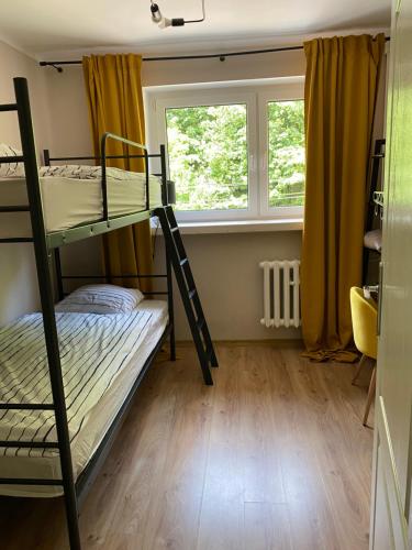 a room with two bunk beds and a window at Apartament w Zdroju in Duszniki Zdrój