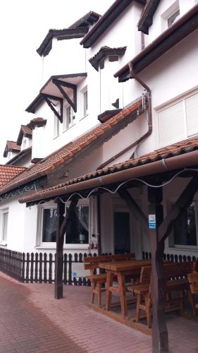 a building with wooden benches in front of it at Hotel Dworek in Wrocław