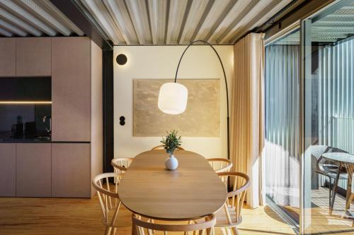 a dining room with a wooden table and chairs at Feel Porto Matosinhos City Flats in Matosinhos