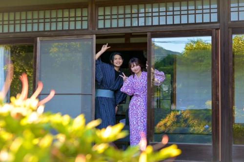um homem e uma mulher à porta em 温泉付きの一軒家を借りよう em Beppu