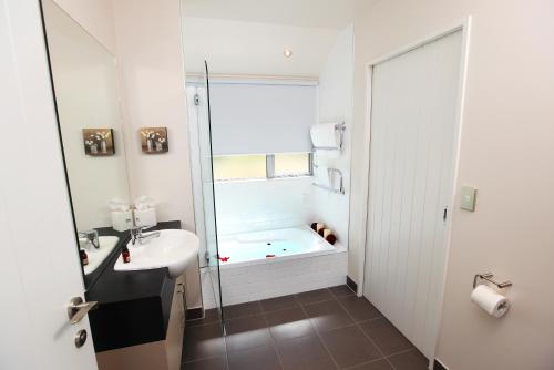 a bathroom with a sink and a bath tub at Arrowfield Apartments in Arrowtown