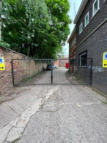 a gate in front of a brick building at Alexandra Apartment -Secured Parking -2 Bedrooms in Crewe