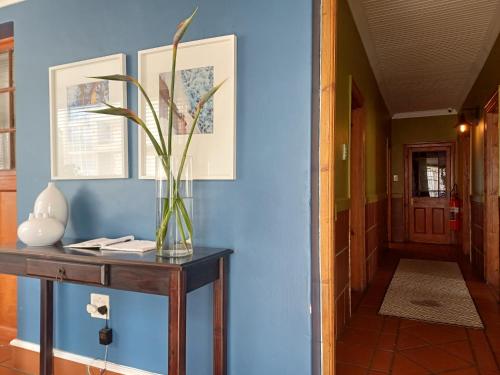 a vase of flowers on a table in a hallway at Loddey`s Guest House - by Beach Collection in Strand