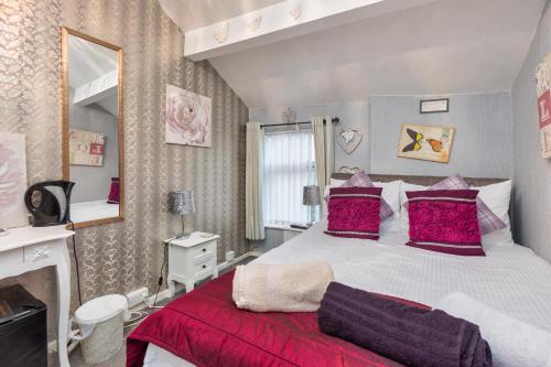 ブラックプールにあるFriends Hotelのベッドルーム1室(大型ベッド1台、赤い枕付)
