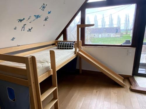 a small room with a bunk bed and a window at Grande Maison familiale in Maillebois