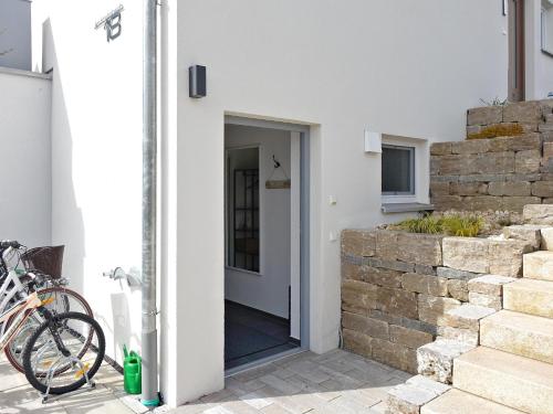 a door to a white house with a stone wall at ELYs-Home in Isny im Allgäu