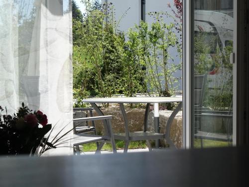 a table and chairs on a patio with a window at ELYs-Home in Isny im Allgäu