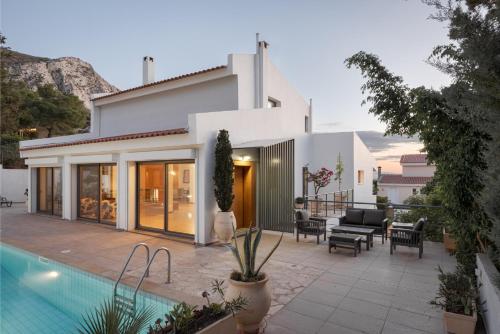 a house with a swimming pool next to a house at Grand Apollon Villa in Sounio