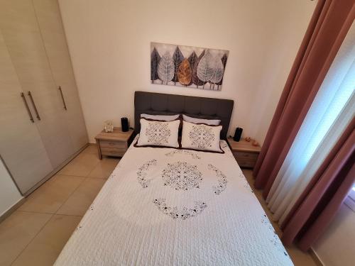 a bedroom with a bed with white sheets and pillows at MACHE's HOME in Patitiri