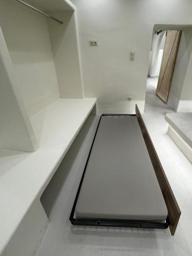 a staircase in a house with white walls at White Sand Jacuzzi Suite in Ios Chora