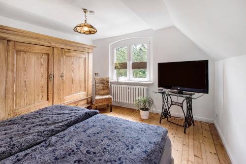 a bedroom with a bed and a flat screen tv at Ferienhaus Waldliebe in Hüttenrode