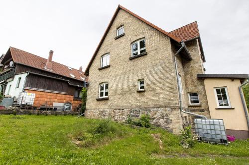 an old brick house in a yard next to two buildings at Ferienhaus Waldliebe in Hüttenrode