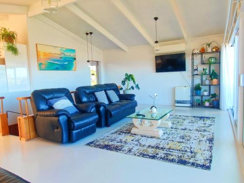 a living room with a blue couch and a table at Delight in Birch-Lake View Holiday Home in Taupo