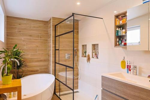 a bathroom with a tub and a sink at Maison proche Disney in Chennevières-sur-Marne