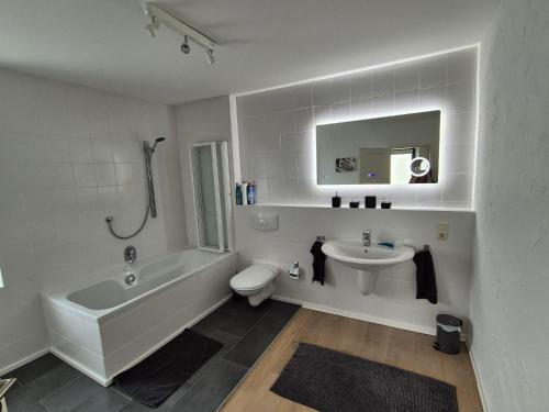 La salle de bains est pourvue d'une baignoire, d'un lavabo et de toilettes. dans l'établissement Hinter'm Mäuerchen, 