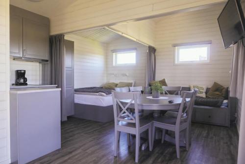 um pequeno quarto com uma mesa e uma cama em Hälleviks Camping em Sölvesborg