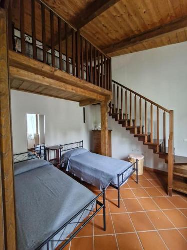 a room with two beds and a staircase at Maya house in Cetona