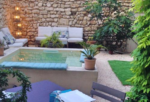 un patio avec piscine dans un jardin dans l'établissement La Capucine, à Cavaillon