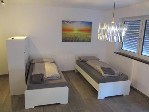 a bedroom with two beds and a painting on the wall at PARSBERGER STADTWOHNUNG 3 in Parsberg