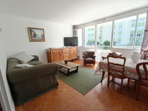 Una sala de estar con un sofá y un televisor. en chambre double lumineuse Paris centre deux pas du métro, en París