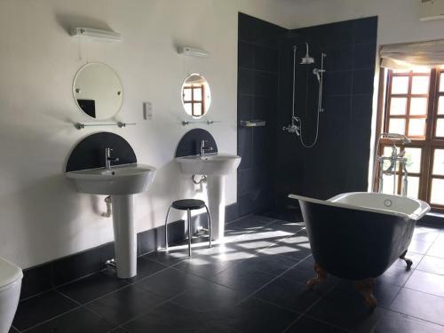 a bathroom with two sinks and a bath tub at Ballimore Farm Estate - House with heated pool in Taynuilt