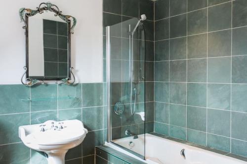 a bathroom with a sink and a mirror and a tub at Ballimore Farm Estate - House with heated pool in Taynuilt