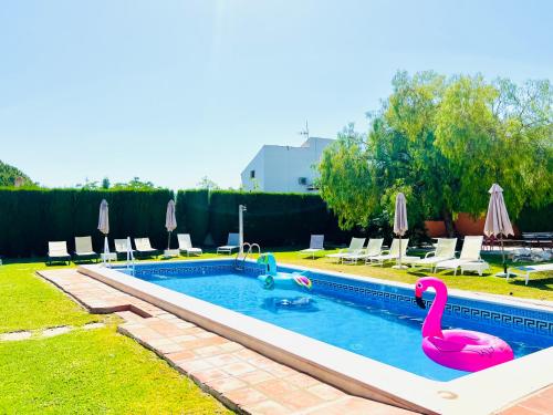 una piscina con dos flamencos rosas. en VILLA SOL Y LUNA Mediterránea, en Alhaurín de la Torre