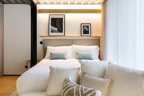 a bedroom with a white bed and a couch at Feel Porto Matosinhos City Flats in Matosinhos