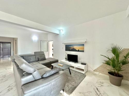 a living room with a couch and a tv at STARS RESIDENCE in Petrovac na Moru