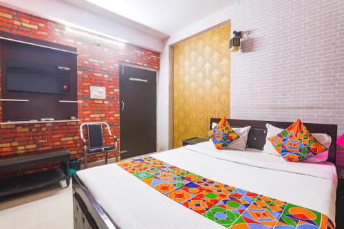 a bedroom with two beds and a tv on the wall at FabExpress The Hudco Grand in Patna