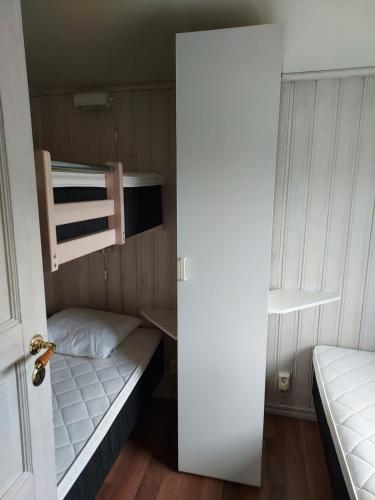 Älgbergets Bed & Breakfast في Ucklum: غرفة صغيرة بها سريرين بطابقين وباب
