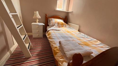 a small bedroom with a bed and a staircase at Richard's Home in Kidderminster