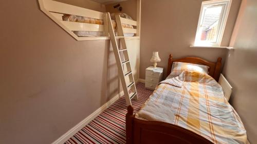 a bedroom with a bunk bed with a ladder at Richard's Home in Kidderminster