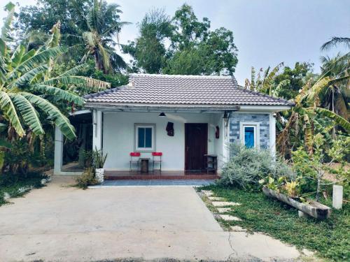 a small white house with a pathway leading to it at Primprey Second Home in Battambang
