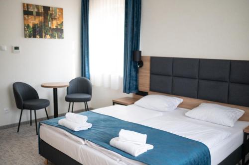 1 dormitorio con 1 cama con 2 toallas en Folwark Pszczew en Pszczew