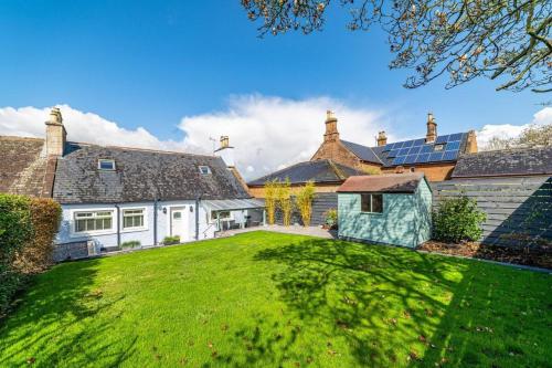 an exterior view of a house with a green yard at Riverside Retreat in Dumfries in Dumfries