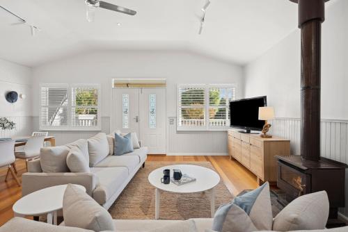 a living room with a couch and a tv at Swyn Y Mor Riverside Cottage Haven in Ocean Grove